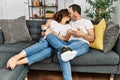 Middle age hispanic couple watching movie and eating popcorn sitting on the sofa at home Royalty Free Stock Photo