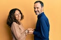 Middle age hispanic couple wearing casual clothes pointing aside with hands open palms showing copy space, presenting Royalty Free Stock Photo