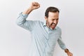 Middle age hispanic man with beard standing over isolated background dancing happy and cheerful, smiling moving casual and Royalty Free Stock Photo