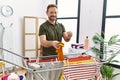 Middle age hispanic man hanging clothes at clothesline at laundry room