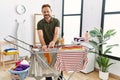 Middle age hispanic man hanging clothes at clothesline at laundry room