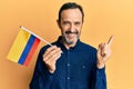 Middle age hispanic man holding colombia flag smiling happy pointing with hand and finger to the side Royalty Free Stock Photo