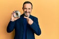 Middle age hispanic man holding compact disc smiling happy pointing with hand and finger Royalty Free Stock Photo