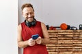 Middle age hispanic man using smartphone wearing headphones at sport center Royalty Free Stock Photo