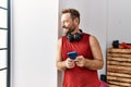 Middle age hispanic man using smartphone wearing headphones at sport center Royalty Free Stock Photo