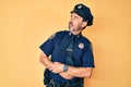 Middle age hispanic man wearing police uniform looking to the side with arms crossed convinced and confident Royalty Free Stock Photo