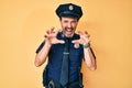 Middle age hispanic man wearing police uniform smiling funny doing claw gesture as cat, aggressive and sexy expression Royalty Free Stock Photo