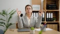 Middle age hispanic woman business worker doing yoga exercise at office Royalty Free Stock Photo