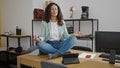 Middle age hispanic woman business worker doing yoga exercise at office Royalty Free Stock Photo