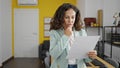 Middle age hispanic woman business worker reading document with doubt expression at office Royalty Free Stock Photo