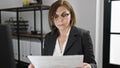 Middle age hispanic woman business worker reading document at office Royalty Free Stock Photo