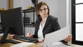 Middle age hispanic woman business worker reading document at office Royalty Free Stock Photo