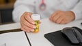 Middle age hispanic woman doctor holding bottle of pills at the clinic Royalty Free Stock Photo