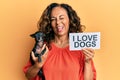 Middle age hispanic woman holding chihuahua dog and paper with i love dogs phrase winking looking at the camera with sexy Royalty Free Stock Photo