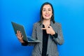 Middle age hispanic woman holding laptop smiling happy pointing with hand and finger Royalty Free Stock Photo