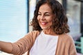 Middle age hispanic woman moving hand asking to come nearer outdoors Royalty Free Stock Photo