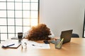 Middle age hispanic woman overworked with head on table at office