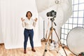 Middle age hispanic woman posing as model at photography studio celebrating mad and crazy for success with arms raised and closed Royalty Free Stock Photo