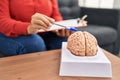 Middle age hispanic woman psychologist pointing to brain at psychology center Royalty Free Stock Photo