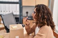 Middle age hispanic woman sending a voice message at ecommerce Royalty Free Stock Photo