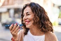 Middle age hispanic woman sending a voice message outdoors Royalty Free Stock Photo