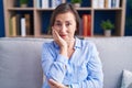 Middle age hispanic woman sitting on the sofa at home thinking looking tired and bored with depression problems with crossed arms Royalty Free Stock Photo