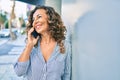 Middle age hispanic woman smiling happy and talking on the smartphone at the city Royalty Free Stock Photo