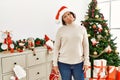 Middle age hispanic woman standing by christmas tree depressed and worry for distress, crying angry and afraid Royalty Free Stock Photo
