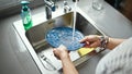 Middle age hispanic woman washing plates at the kitchen Royalty Free Stock Photo