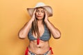 Middle age hispanic woman wearing bikini and summer hat with hand on head for pain in head because stress Royalty Free Stock Photo