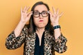 Middle age hispanic woman wearing business clothes and holding glasses puffing cheeks with funny face Royalty Free Stock Photo