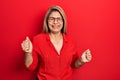 Middle age hispanic woman wearing casual clothes and glasses very happy and excited doing winner gesture with arms raised, smiling Royalty Free Stock Photo