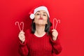 Middle age hispanic woman wearing christmas hat holding candy looking at the camera blowing a kiss being lovely and sexy Royalty Free Stock Photo