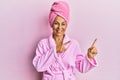 Middle age hispanic woman wearing shower towel cap and bathrobe smiling and looking at the camera pointing with two hands and Royalty Free Stock Photo