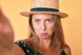 Middle age hispanic woman wearing summer hat taking a selfie depressed and worry for distress, crying angry and afraid Royalty Free Stock Photo