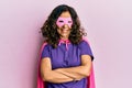 Middle age hispanic woman wearing super hero costume happy face smiling with crossed arms looking at the camera