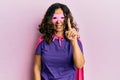 Middle age hispanic woman wearing super hero costume smiling with an idea or question pointing finger up with happy face, number