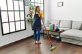 Middle age hispanic woman working as housekeeper dancing at home Royalty Free Stock Photo