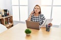 Middle age hispanic woman working at the office with laptop speaking on the phone looking at the camera blowing a kiss being Royalty Free Stock Photo