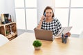 Middle age hispanic woman working at the office with laptop speaking on the phone winking looking at the camera with sexy Royalty Free Stock Photo