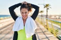 Middle age hispanic woman working out fixing hair at promenade