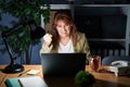 Middle age hispanic woman working using computer laptop at night angry and mad raising fist frustrated and furious while shouting Royalty Free Stock Photo