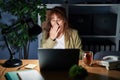 Middle age hispanic woman working using computer laptop at night bored yawning tired covering mouth with hand Royalty Free Stock Photo