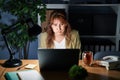 Middle age hispanic woman working using computer laptop at night puffing cheeks with funny face Royalty Free Stock Photo
