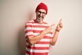 Middle age hoary man wearing striped t-shirt glasses and cap over isolated white background smiling and looking at the camera Royalty Free Stock Photo