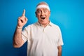 Middle age hoary sportsman doing sport wearing sportswear over isolated blue background pointing finger up with successful idea Royalty Free Stock Photo