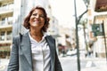 Middle age latin businesswoman smiling happy standing at the city
