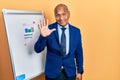 Middle age latin man wearing business clothes on chart presentation waiving saying hello happy and smiling, friendly welcome