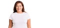 Middle age latin woman wearing casual white tshirt with a happy and cool smile on face