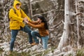 Loving couple with backpack hiking in a beautiful nature. Helping hand - hiker woman getting help on hike Royalty Free Stock Photo